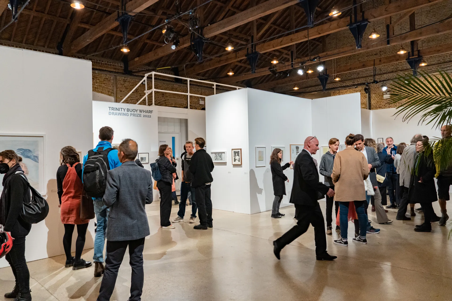 People walking in front of art exhibition panels