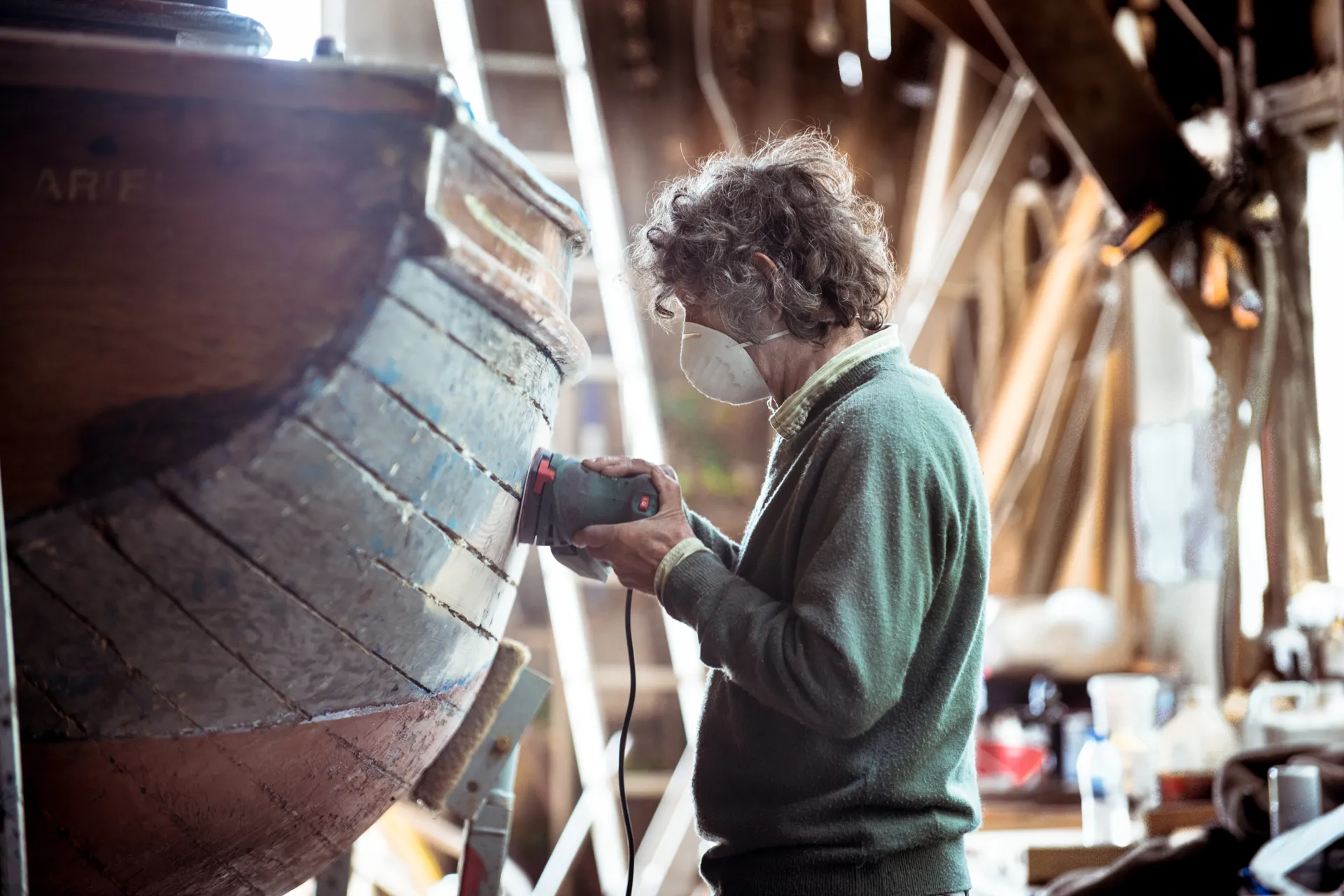 Worker sanding down a boat