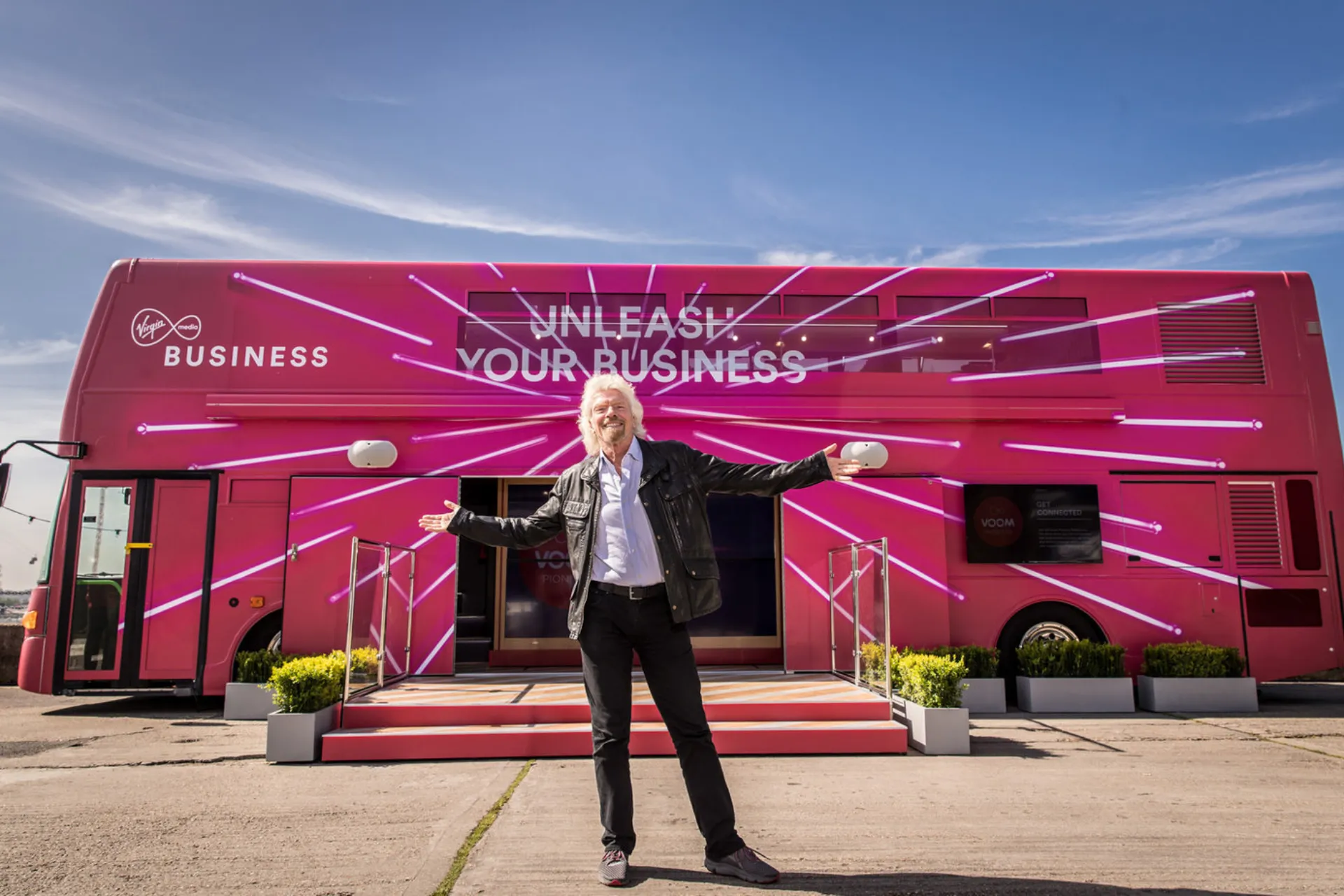 Man standing in front of pink bus